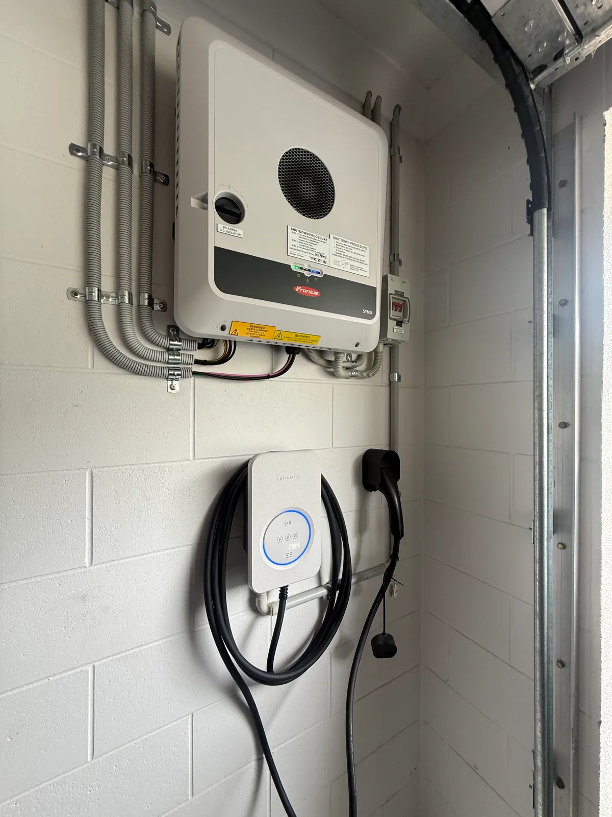 Level 2 home EV charger and solar inverter installed by On Point Solar in a Townsville garage