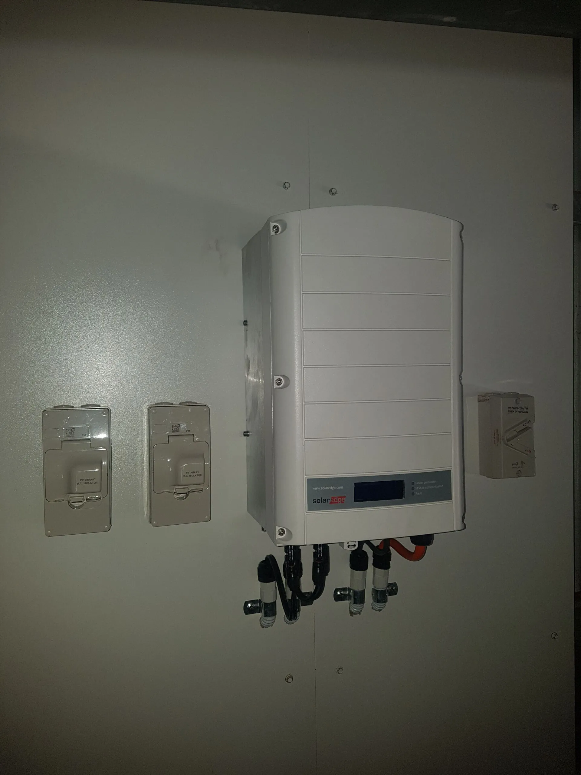 A tidy SolarEdge inverter and labelled DC isolators installed by On Point Solar & Electrical in Townsville