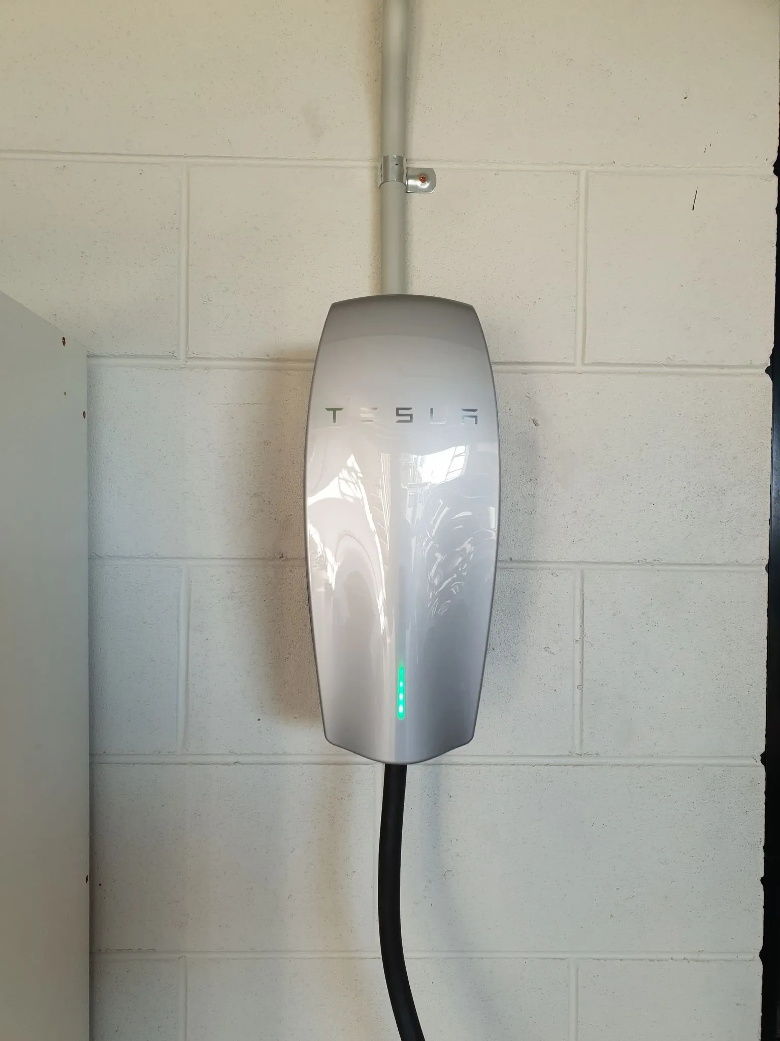 EV charger installation Townsville — a Tesla wall connector fitted by On Point Solar & Electrical in a local garage