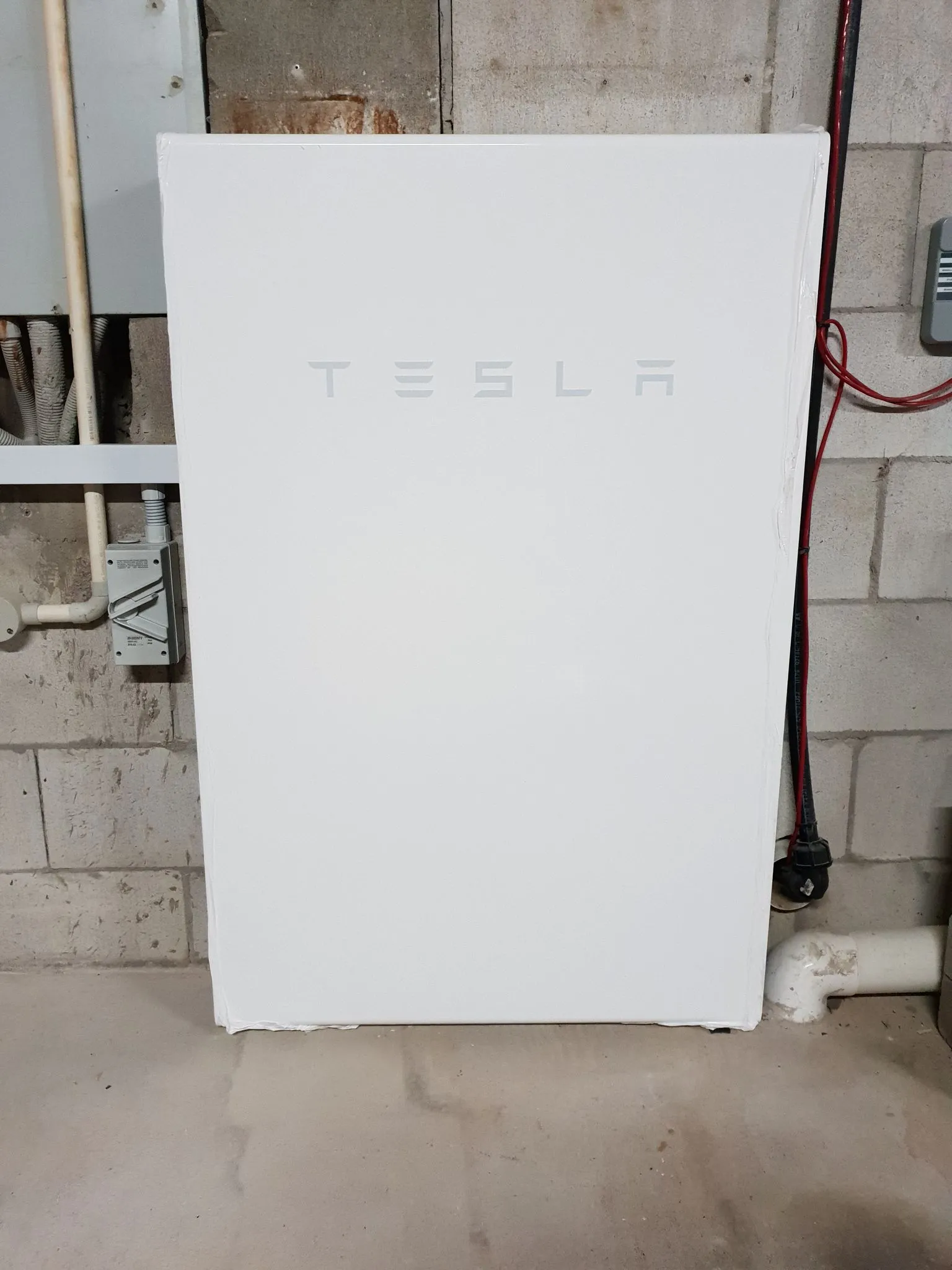 Solar battery storage Townsville — a Tesla Powerwall home battery installed by On Point Solar in a local garage